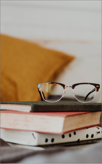 pile of books and glasses on top